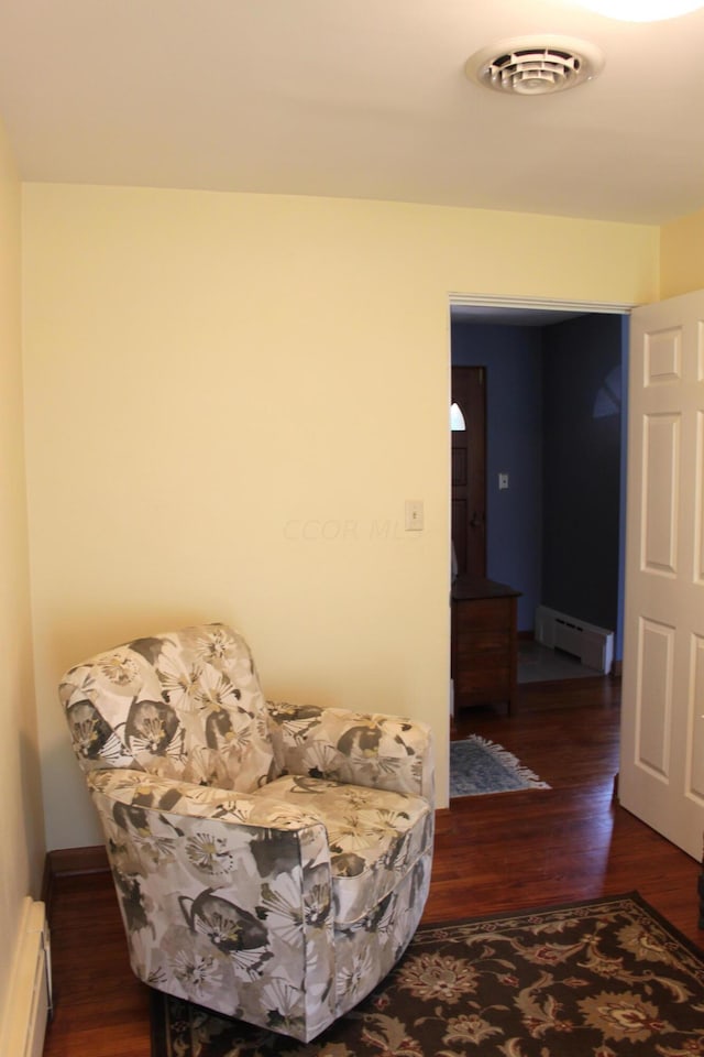 sitting room with baseboard heating and dark wood-type flooring