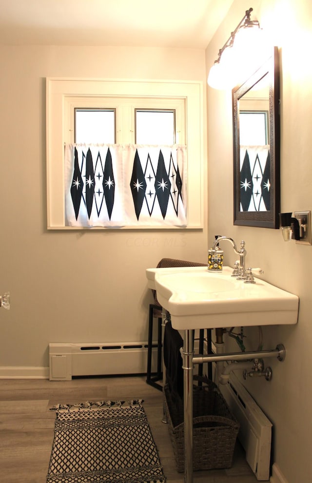 bathroom featuring hardwood / wood-style floors, sink, and a baseboard radiator