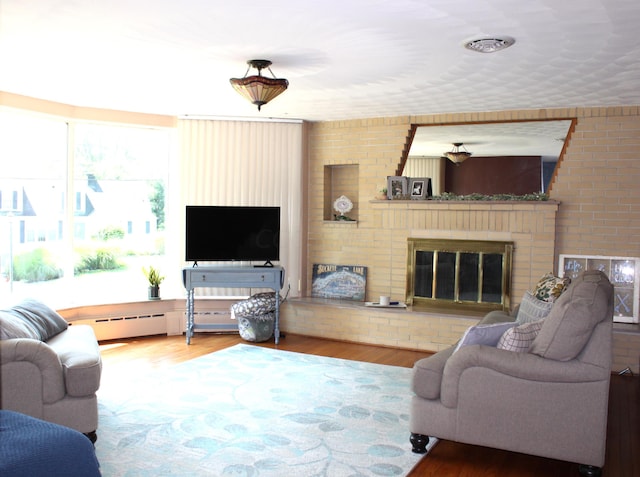 living room featuring a fireplace, wood-type flooring, and baseboard heating