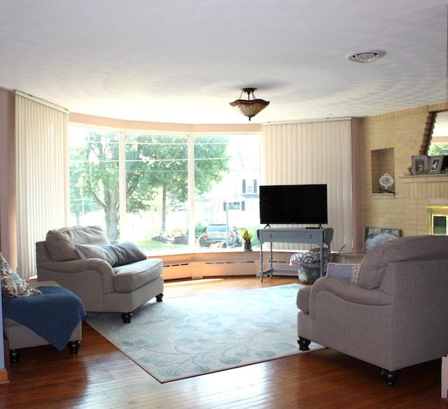 living room featuring wood-type flooring and a brick fireplace