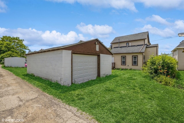 exterior space with an outbuilding, a garage, and a lawn