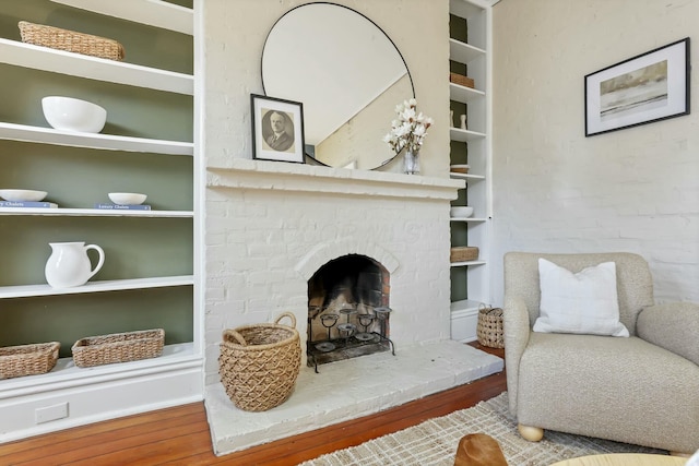 living room with a fireplace, hardwood / wood-style floors, and built in features