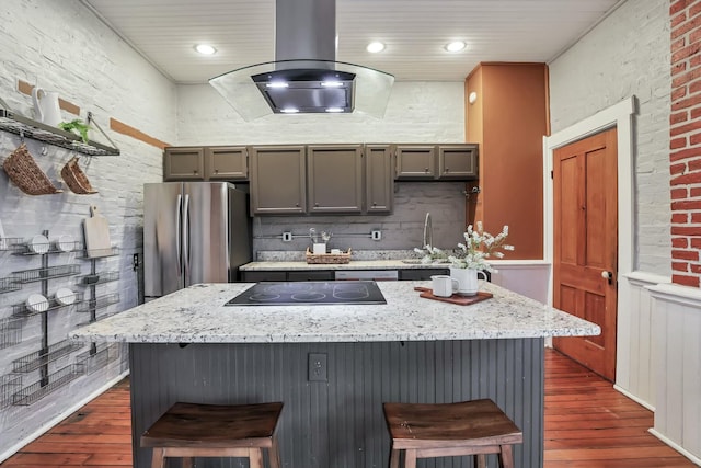 kitchen with gray cabinetry, island range hood, dark hardwood / wood-style flooring, and stainless steel refrigerator