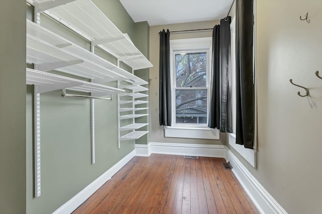 walk in closet with hardwood / wood-style flooring