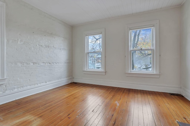 unfurnished room with hardwood / wood-style flooring and crown molding