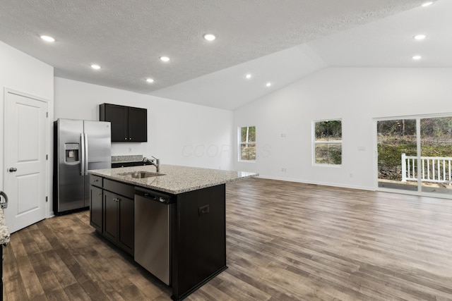 kitchen featuring lofted ceiling, a center island with sink, sink, dark hardwood / wood-style flooring, and stainless steel appliances