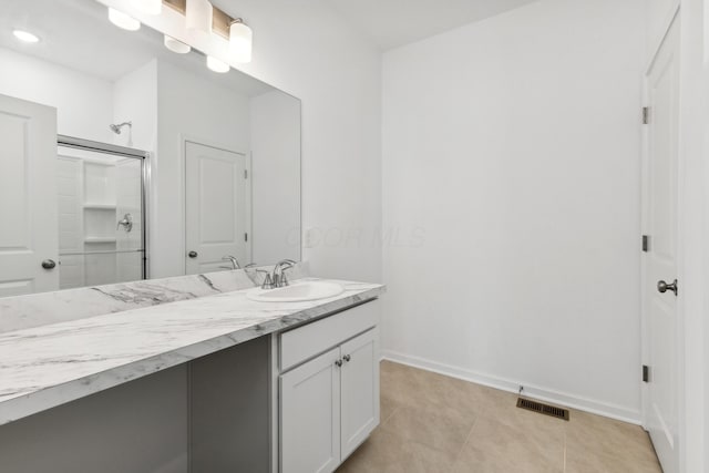 bathroom featuring tile patterned flooring, vanity, and walk in shower