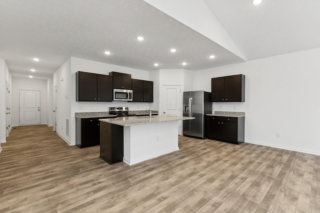 kitchen featuring sink, light hardwood / wood-style floors, a kitchen island with sink, dark brown cabinets, and appliances with stainless steel finishes