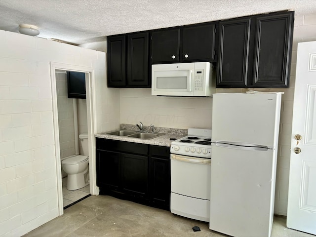 kitchen featuring a textured ceiling, white appliances, and sink