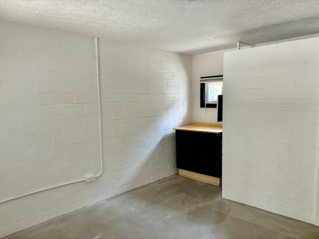 bathroom with concrete flooring and a textured ceiling