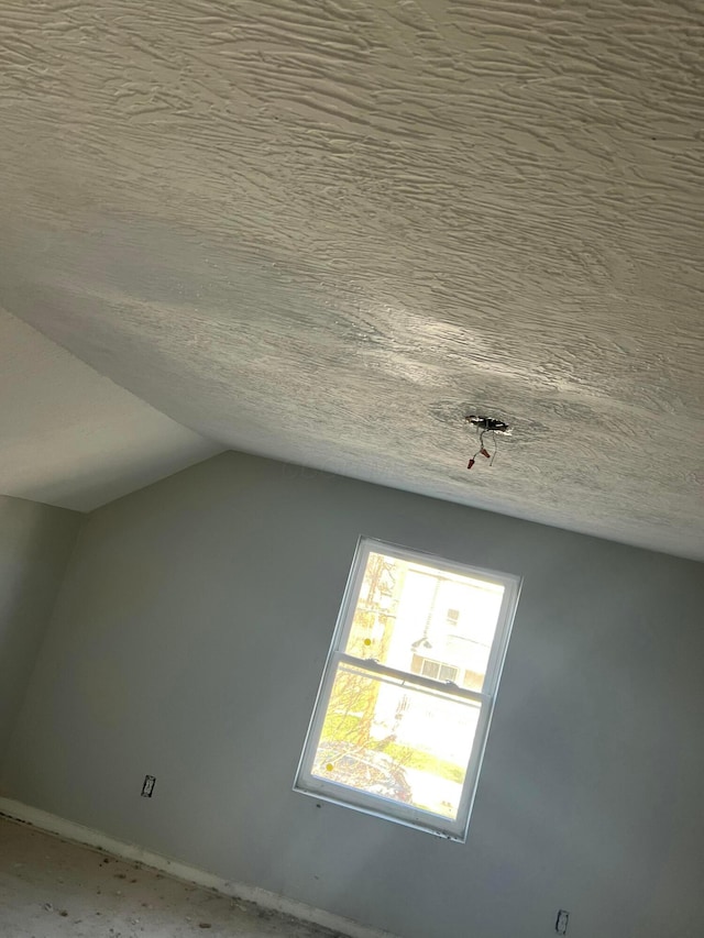 bonus room featuring a textured ceiling and lofted ceiling