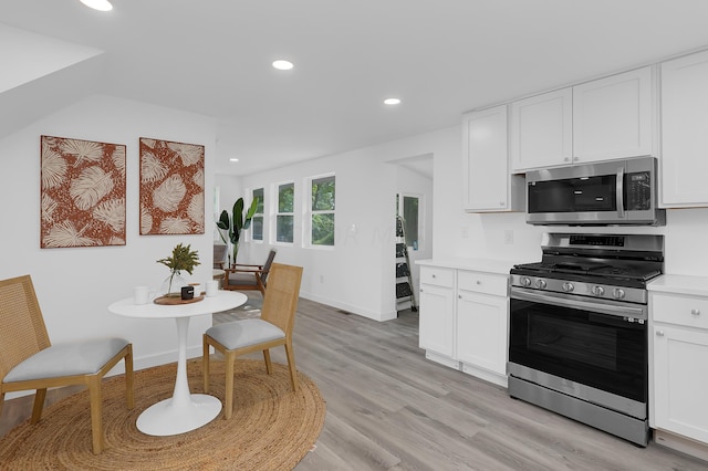 kitchen with white cabinets, light hardwood / wood-style floors, and stainless steel appliances