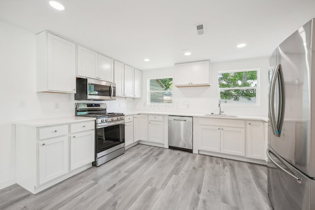 kitchen featuring sink, white cabinets, and appliances with stainless steel finishes