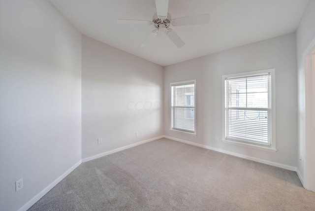 spare room featuring light colored carpet and ceiling fan