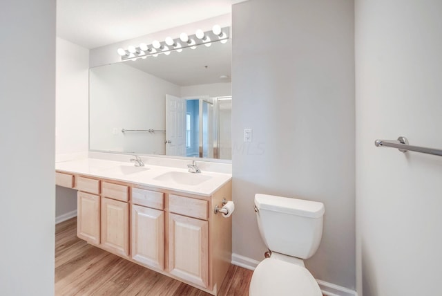 bathroom with vanity, toilet, wood-type flooring, and walk in shower