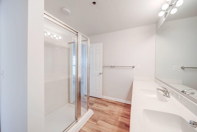 bathroom featuring hardwood / wood-style floors, vanity, an inviting chandelier, and walk in shower