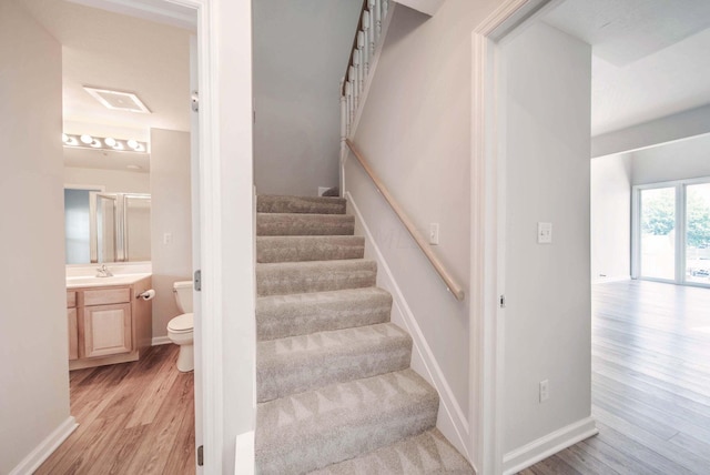 stairs with sink and wood-type flooring