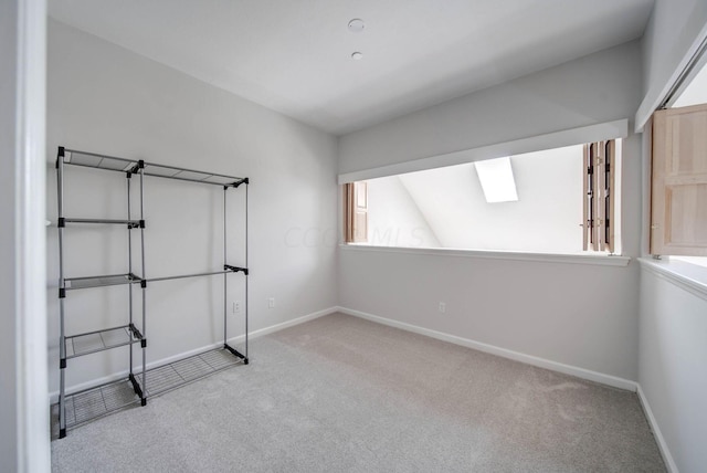 unfurnished bedroom featuring light carpet and lofted ceiling