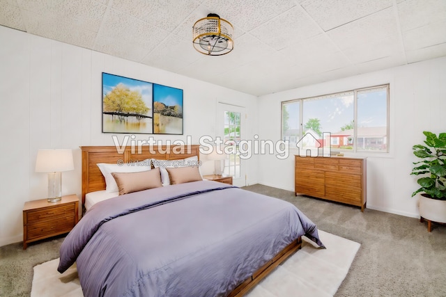 carpeted bedroom featuring a drop ceiling