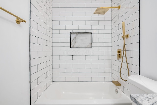 bathroom with tiled shower / bath combo and toilet