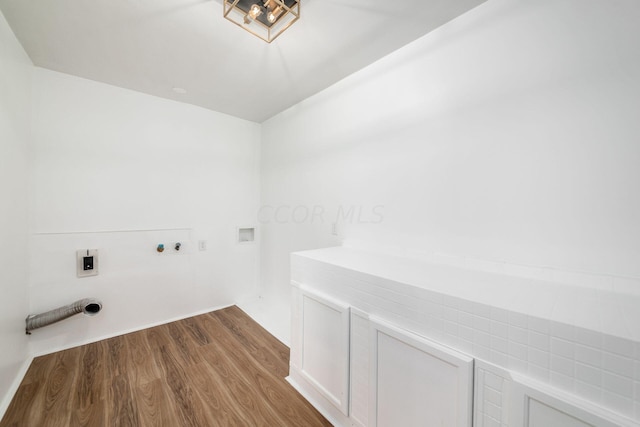 laundry room featuring electric dryer hookup, cabinets, hookup for a washing machine, and light hardwood / wood-style flooring