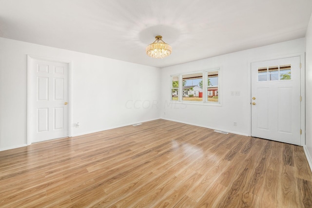 entryway featuring light hardwood / wood-style flooring and an inviting chandelier