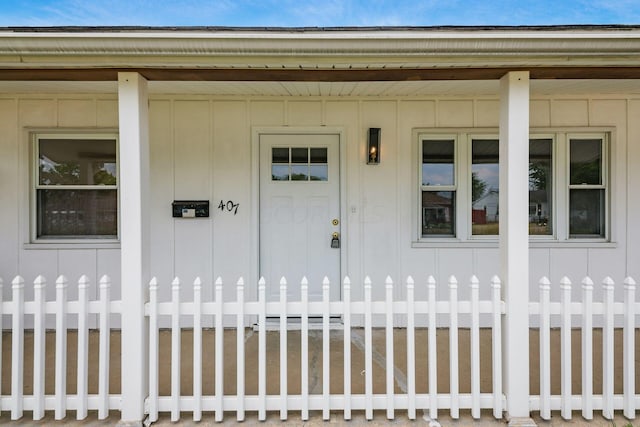 view of exterior entry featuring covered porch