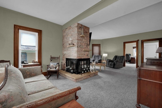 carpeted living room with a stone fireplace