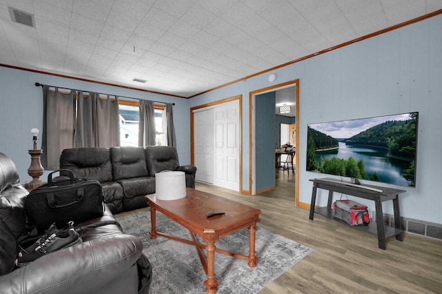 living room with hardwood / wood-style flooring and crown molding