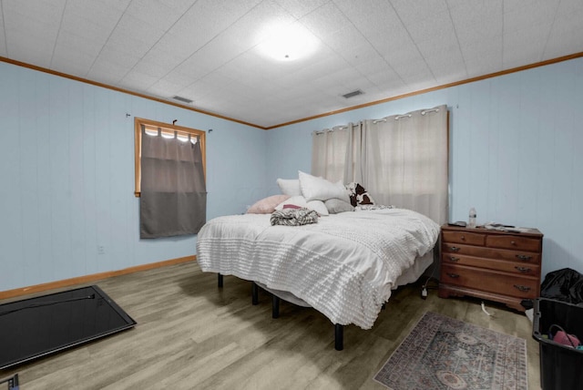 bedroom with crown molding and hardwood / wood-style flooring