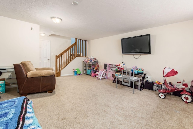 recreation room featuring carpet and a textured ceiling