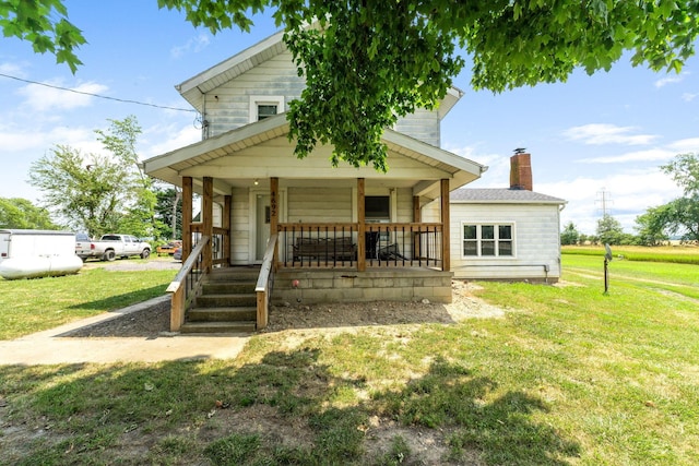 back of property featuring a lawn and a porch