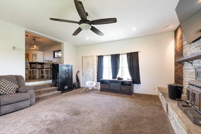 carpeted living room with ceiling fan with notable chandelier