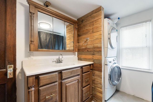 clothes washing area featuring stacked washer / dryer and sink