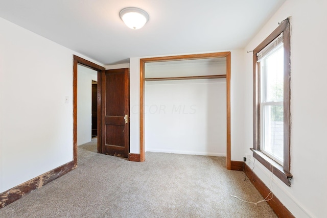 unfurnished bedroom featuring carpet flooring and a closet