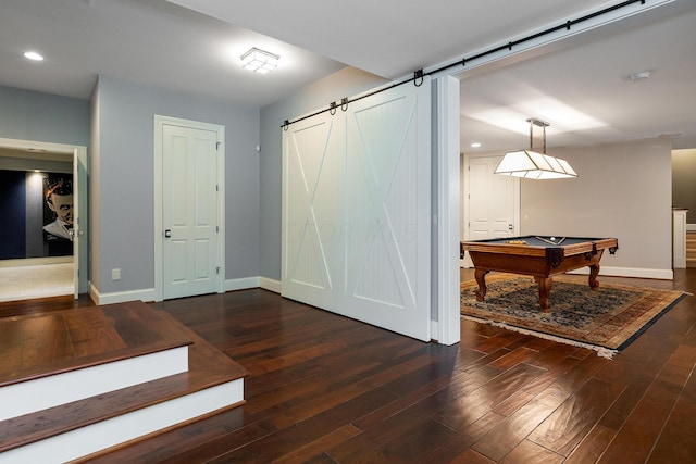 hall with a barn door and dark wood-type flooring