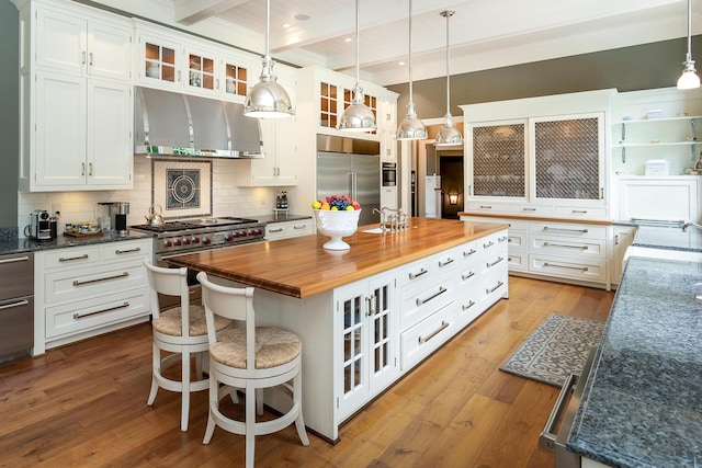 kitchen featuring white cabinets, beam ceiling, a kitchen island, and high quality appliances