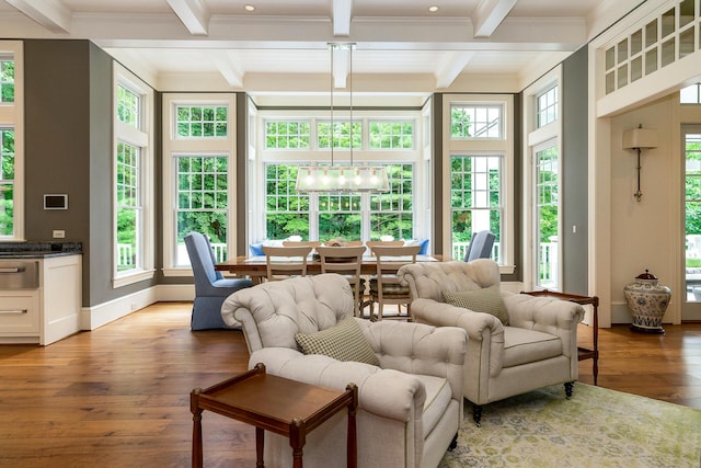 sunroom / solarium with plenty of natural light, beamed ceiling, and an inviting chandelier