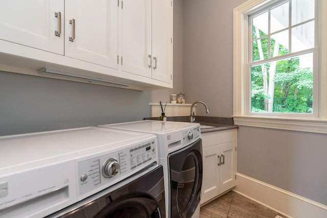 washroom featuring tile patterned floors, washing machine and dryer, sink, and cabinets