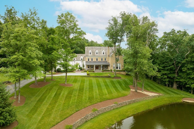 back of house with a yard and a water view