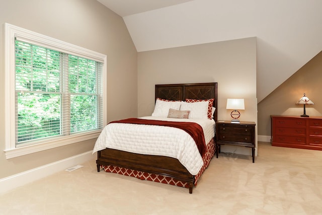 bedroom featuring light colored carpet, vaulted ceiling, and multiple windows