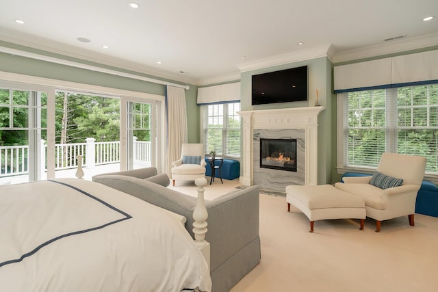 bedroom with a high end fireplace, light colored carpet, ornamental molding, and access to outside