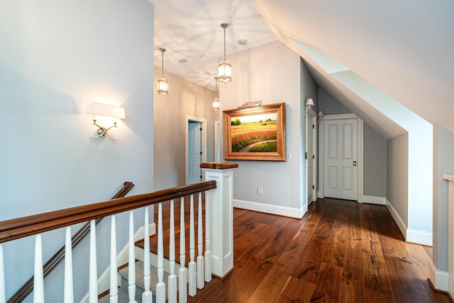 hallway with dark hardwood / wood-style floors and vaulted ceiling