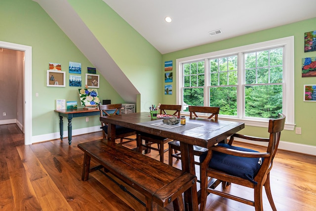 dining area with lofted ceiling and hardwood / wood-style flooring