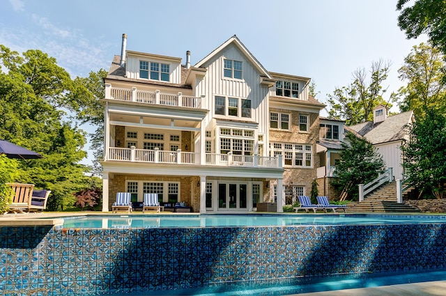 rear view of house featuring a balcony and french doors