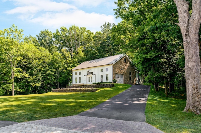 view of front facade with french doors, a garage, and a front lawn