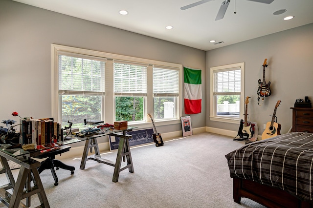 bedroom featuring light colored carpet, multiple windows, and ceiling fan