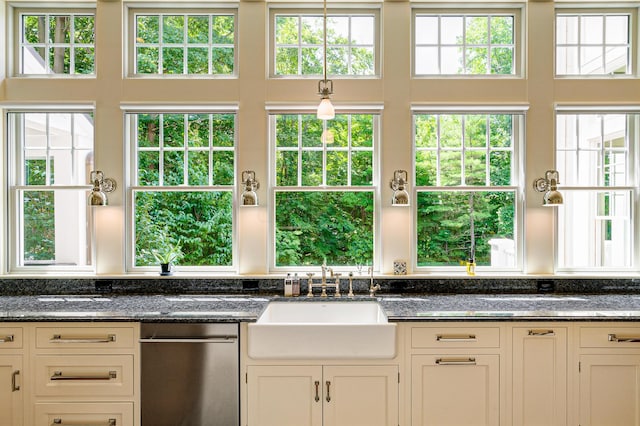 kitchen with white cabinetry, dark stone countertops, and sink