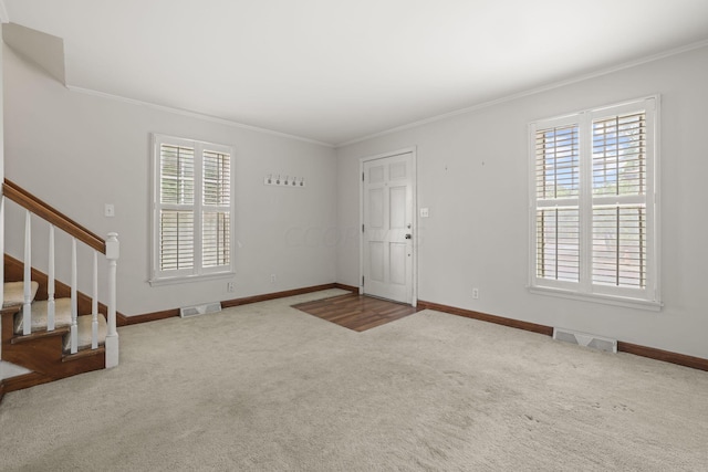 entrance foyer with carpet flooring, plenty of natural light, and crown molding