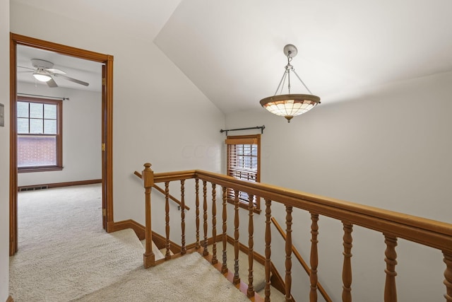 stairway featuring carpet flooring, ceiling fan, and vaulted ceiling